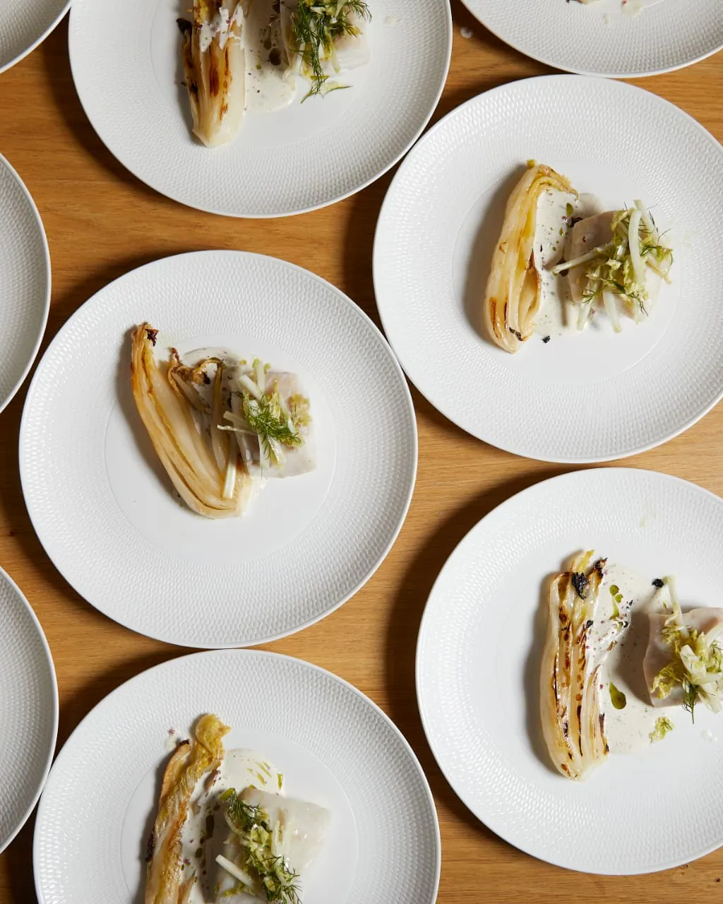 Corporate team gathered around a cooking station during a hands-on team-building event in a Sydney venue.
