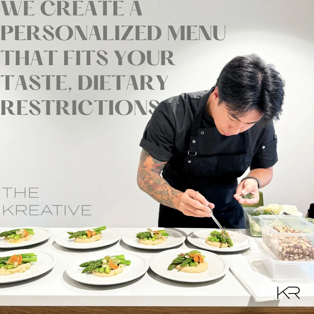 Chef finishing a plated course by hand in a low-lit kitchen at a private Sydney event.