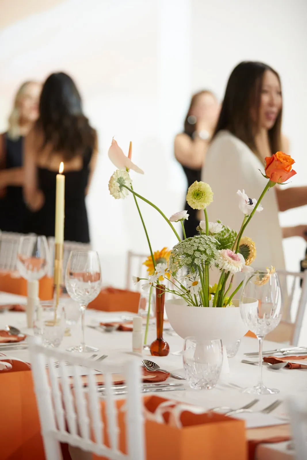 Long banquet table set with florals, candles and crystal glassware at a private celebration.