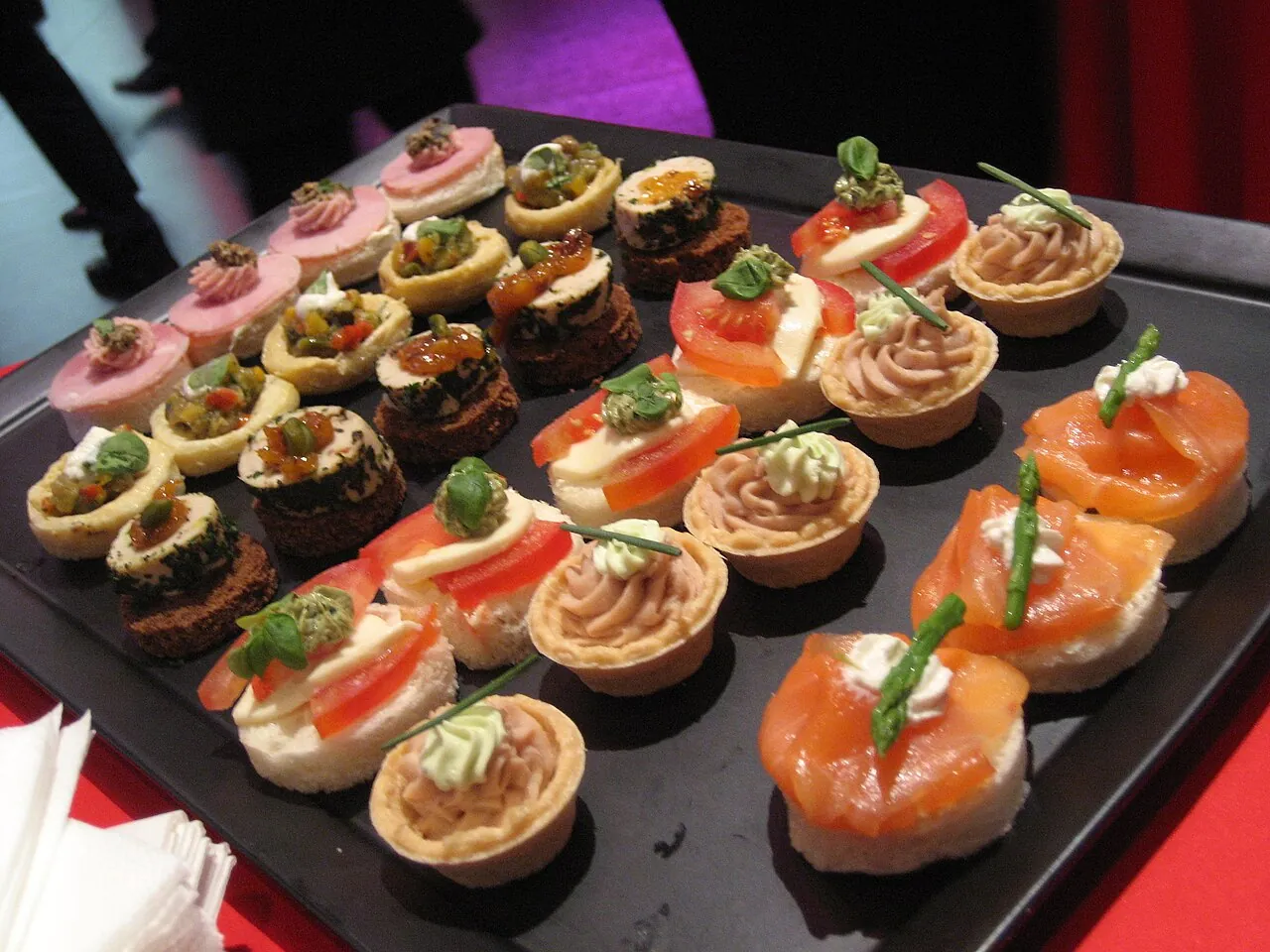 Tray of elegant canapés including smoked salmon, tartlets and garnished bites ready for a wedding reception.